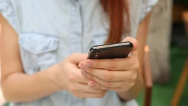 En kvinna som håller i en mobiltelefon