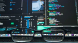 Ett par glasögon framför en datorskärm