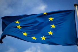 EUs blå och gula stjärnflagga med blå himmel i bakgrunden