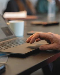 Person typing on a laptop in a modern office setting with a focus on technology and business productivity
