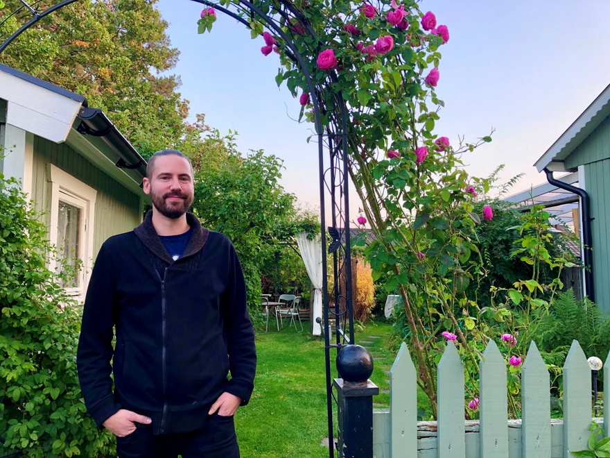 Wezz i sin trädgård med grön gräsmatta och rosor