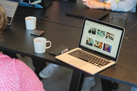 Konferensrum med en bärbar dator på ett bord och ryggen av en kvinna