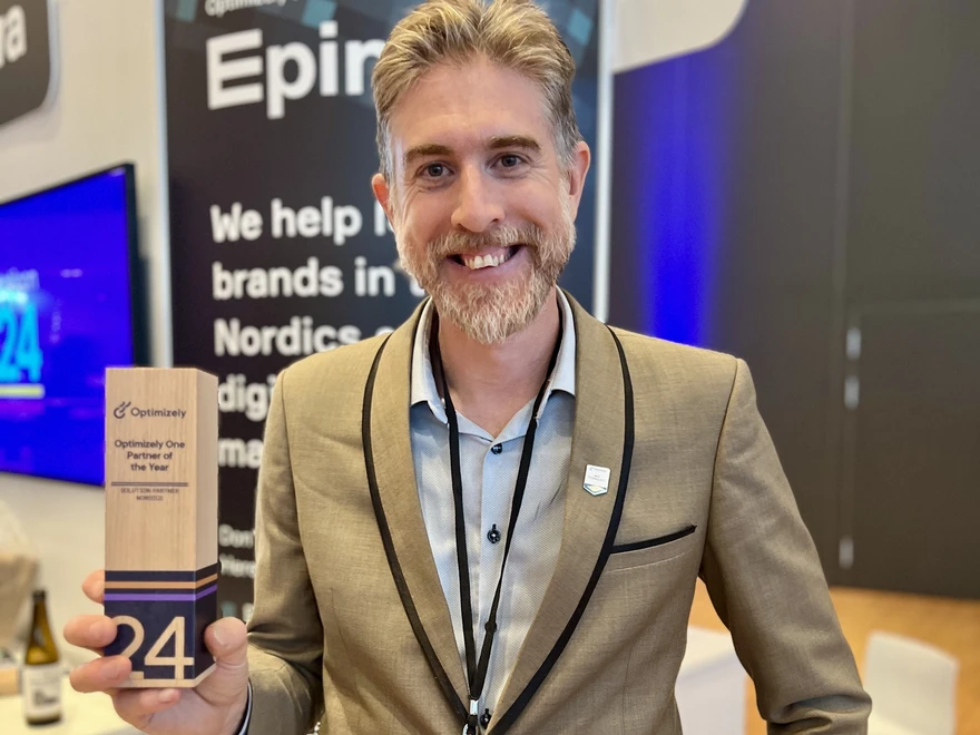 Linus Ekström håller i trästatyetten