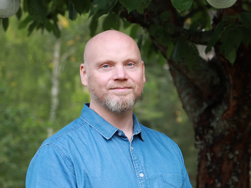 Joacim utomhus med grönska i bakgrunden